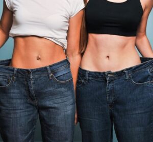 two women showing off their old jean sizes after weight loss