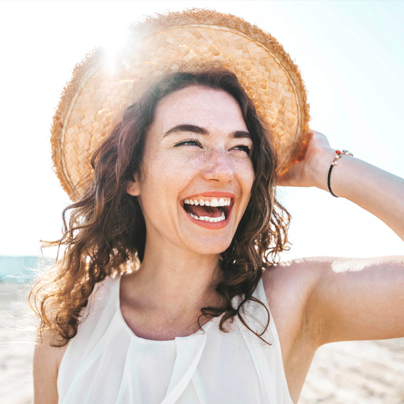 Happy beautiful young woman smiling at the beach side - Delightful girl enjoying sunny day out - Healthy lifestyle concept with female laughing outside