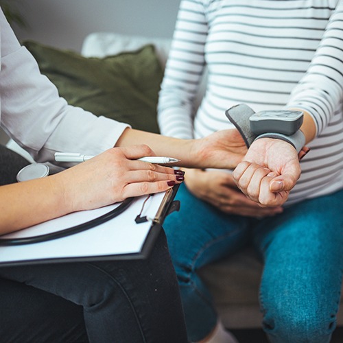 Doctor measuring blood pressure of young woman