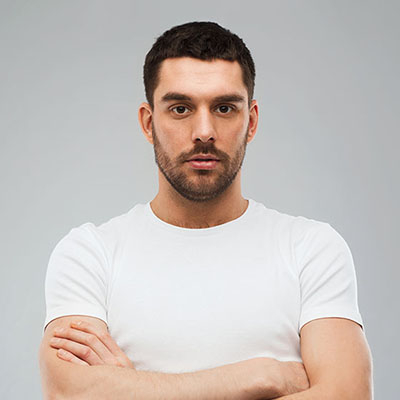 young man with crossed arms over gray background