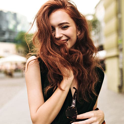 Curly lady smiling and walking through city